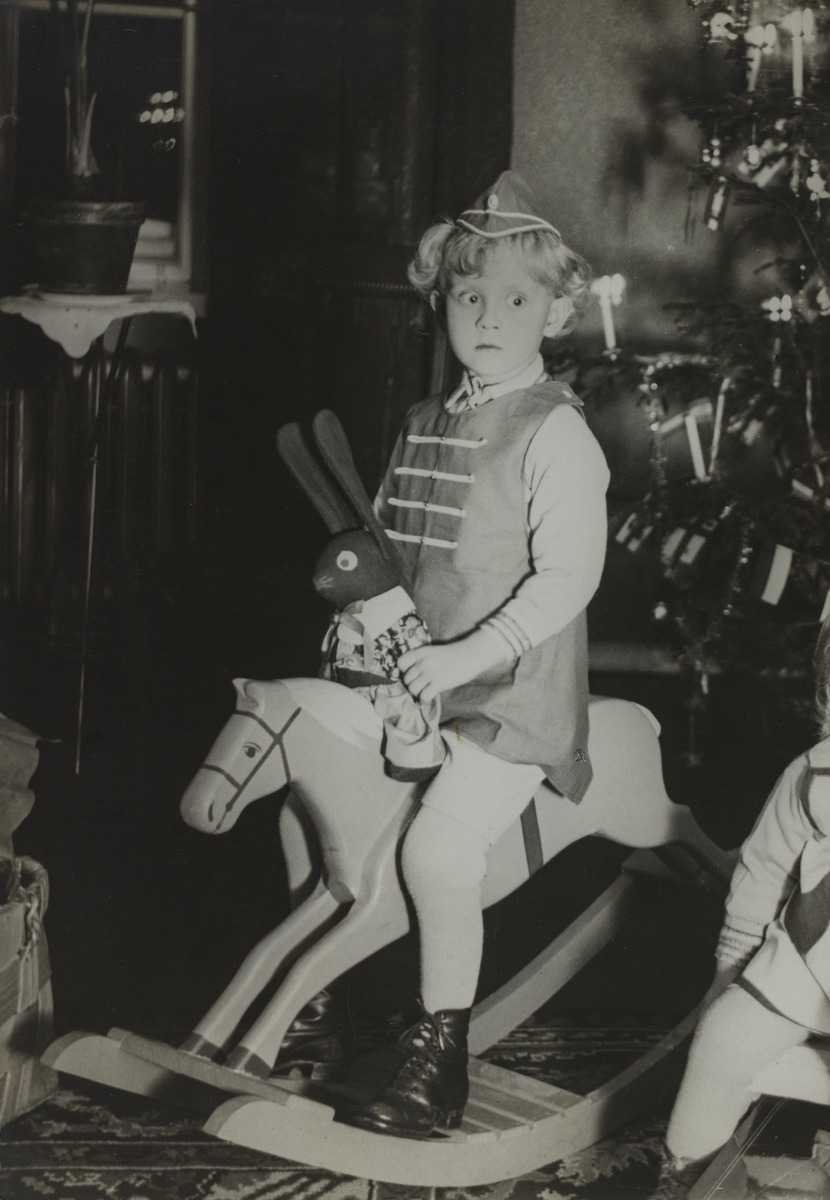 Tyttö ratsastaa puuhevosella jouluna 1927 joulukuusen edessä