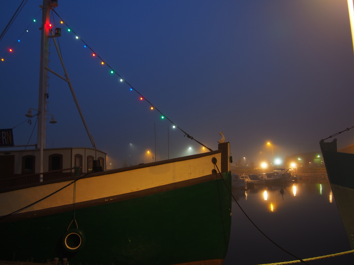 Hieman sumuisessa pimenevässä illassa Herttoniemenrannassa Laivalahdella laituriin kytkettyjä pienaluksia, jotka ovat kokikkain