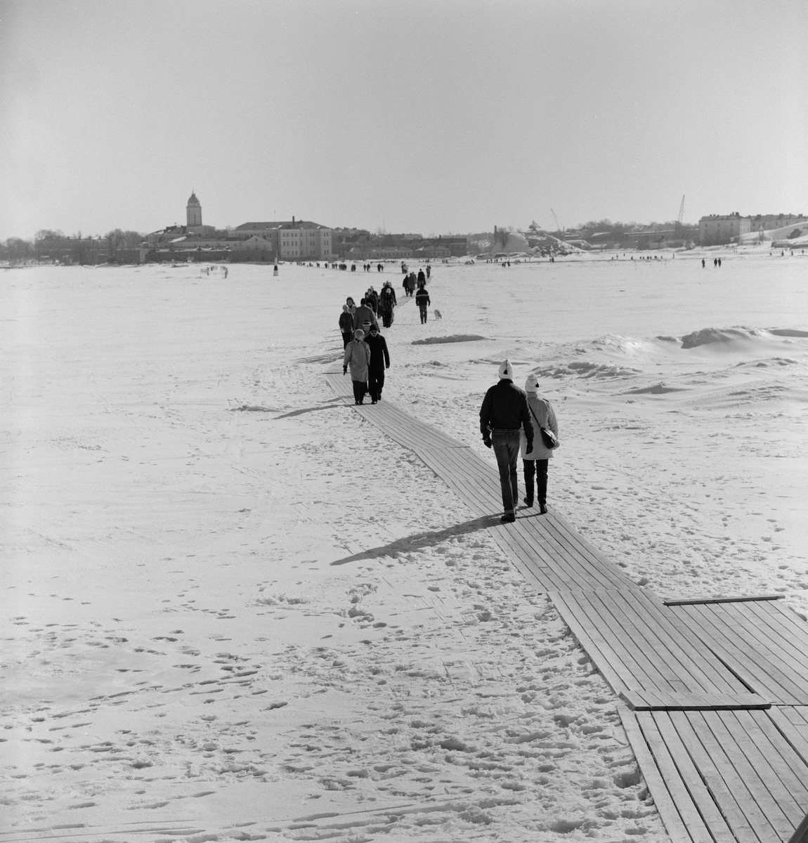 Laudoilla katettu jäätie jalankulkijoille Kaivopuiston rannasta Suomenlinnaan