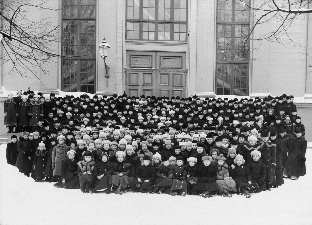 Helsingin Suomalaisen Tyttökoulun oppilaat ryhmäkuvassa Vanhan kirkon ulko-oven edessä