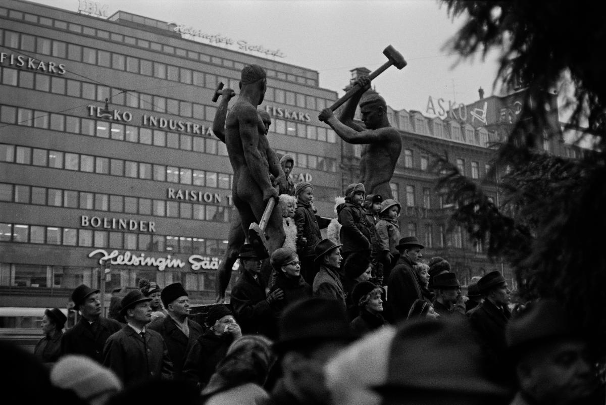 Joulukadun avajaiset, pieniä tyttöjä ja poikia seisoo Kolmen sepän patsaan (kuvanveistäjä Felix Nylund 1932) jalustalla.