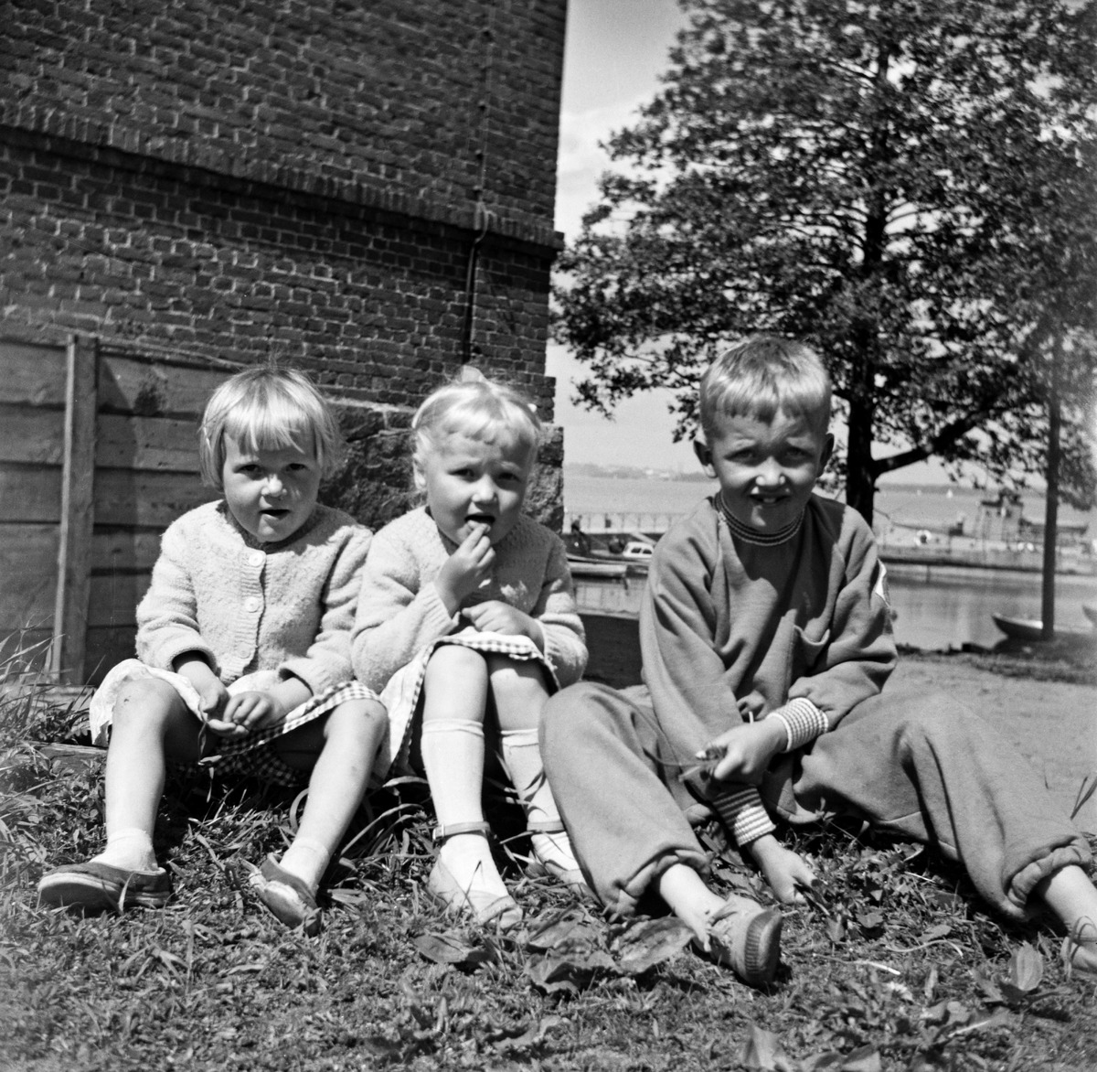 Kolme lasta istuu Vallisaaren luotsitalon itäpäädyssä