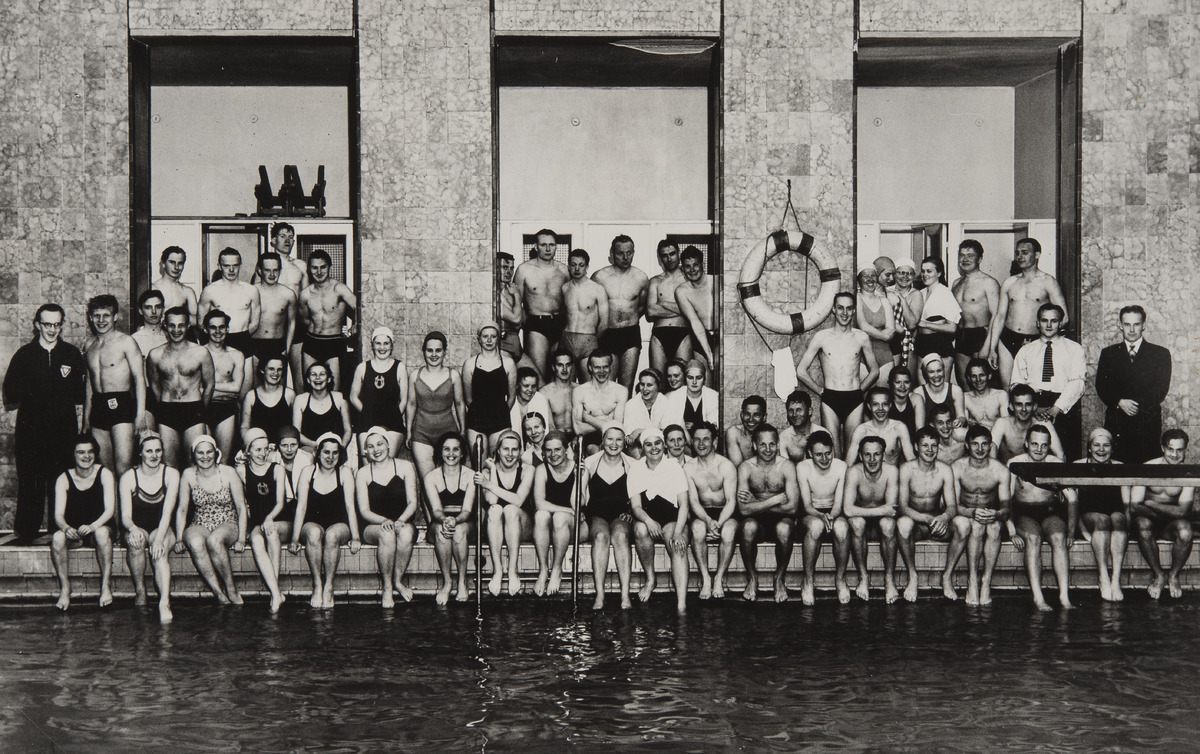 Uimakandidaatteja- ja maistereita sekä heidän valmentajiaan ryhmäkuvassa Yrjönkadun uimahallin ison altaan reunalla