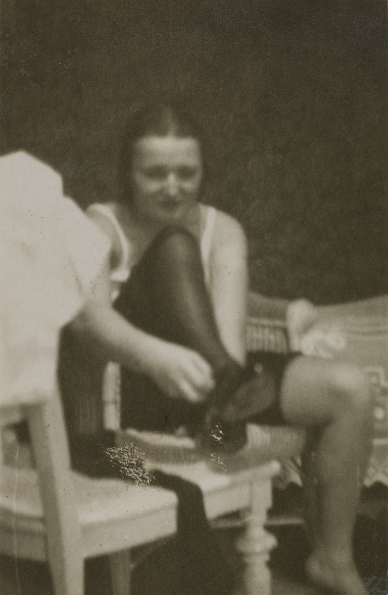 Keraamikko Friedl Holzer-Kjellberg (1905-1993), pukemassa kenkiä ja sukkia