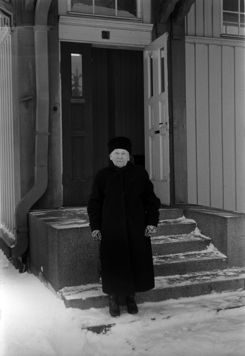 Thyra Achrén (1870-1970) seisomassa Huopalahden asemarakennuksen ulkopuolella