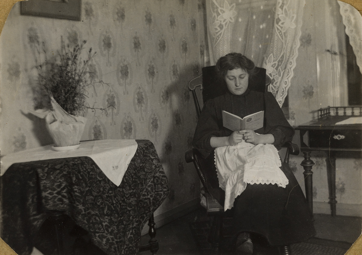 Tiilitehtailija Karl Wilkmanin tytär Aina (Aino) Wilkman lukee kirjaa keinutuolissa seitsemäsluokkalaisena, Liisankatu 16