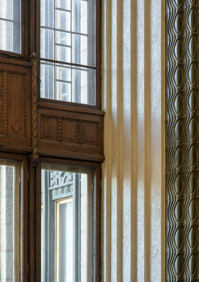Helsingin rautatieaseman asemaravintolan ikkunaseinän vihreiden keraamisten muotolaattojen koristama pilasteri sekä karmi koristeellisine puuleikkauksineen, yksityiskohta