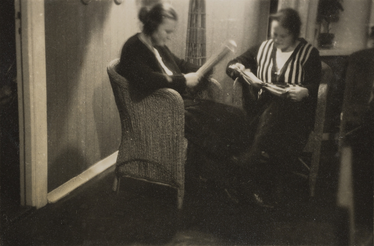 Vasemmalla Friedl Holzer-Kjellberg ja oikealla valokuvaaja Maria Holzer lukemassa lampun valossa