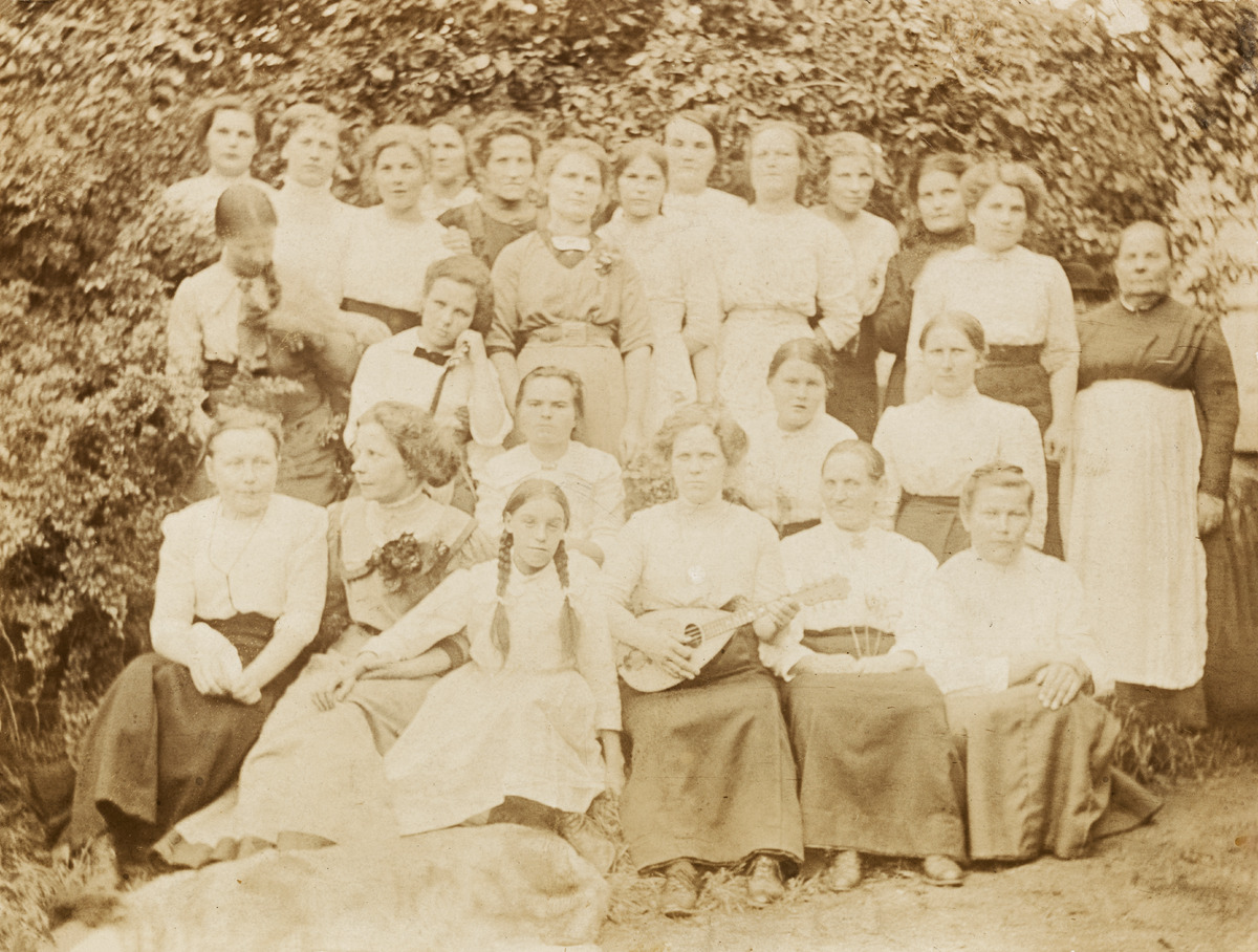 Naisia ryhmäkuvassa, keskellä mandoliinin soittaja
