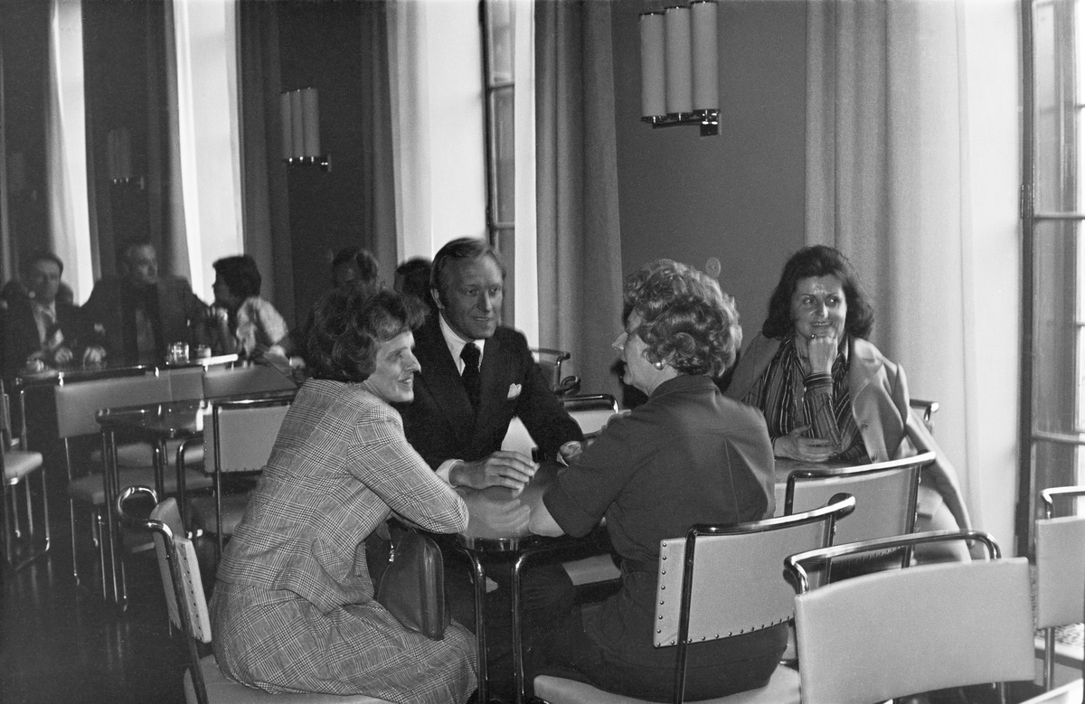 Kokoomuksen kansanedustaja Harri Holkeri istuu kolmen naisen kanssa eduskunnan kahvilassa