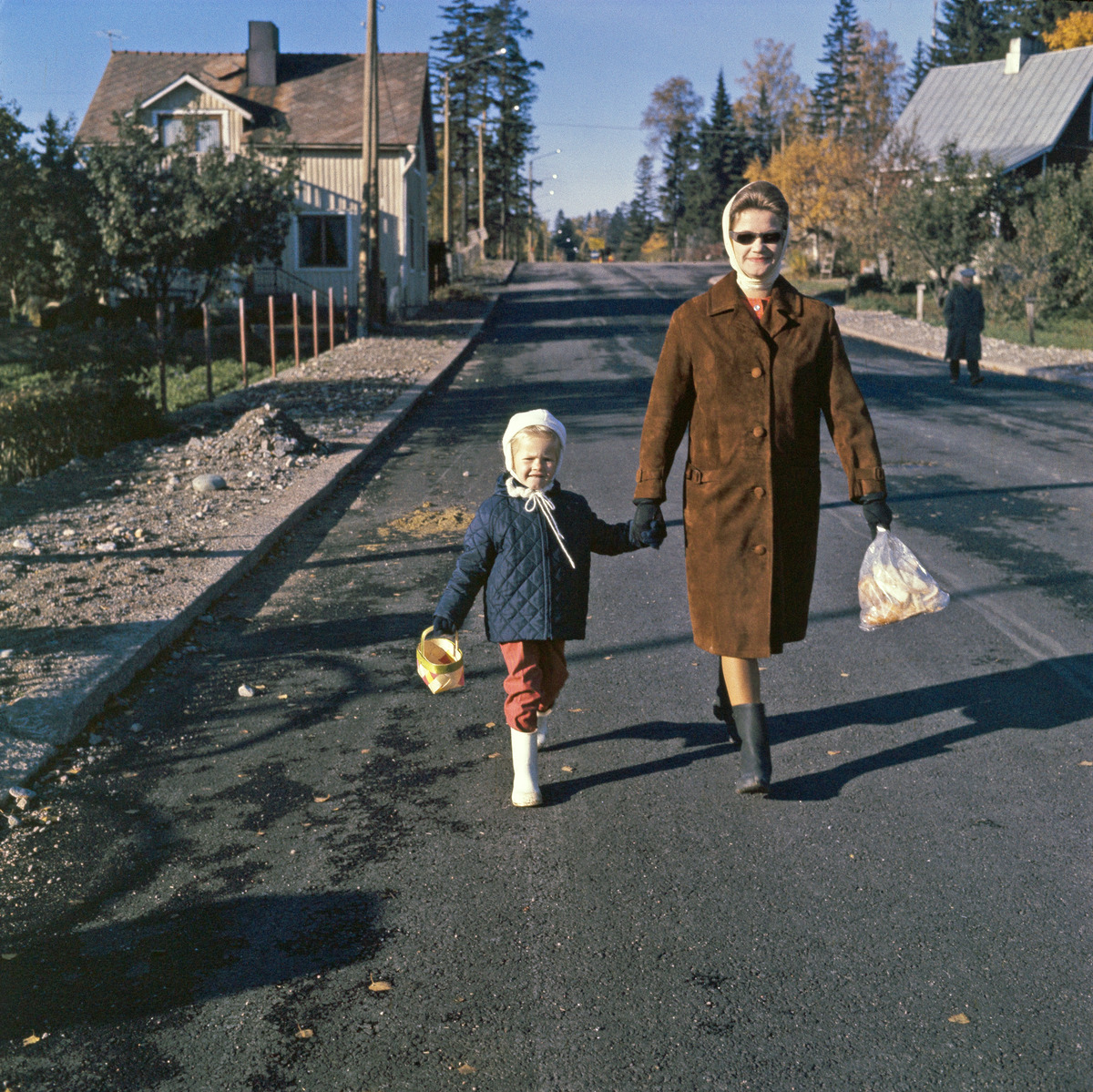 Nainen ja lapsi kävelevät käsi kädessä