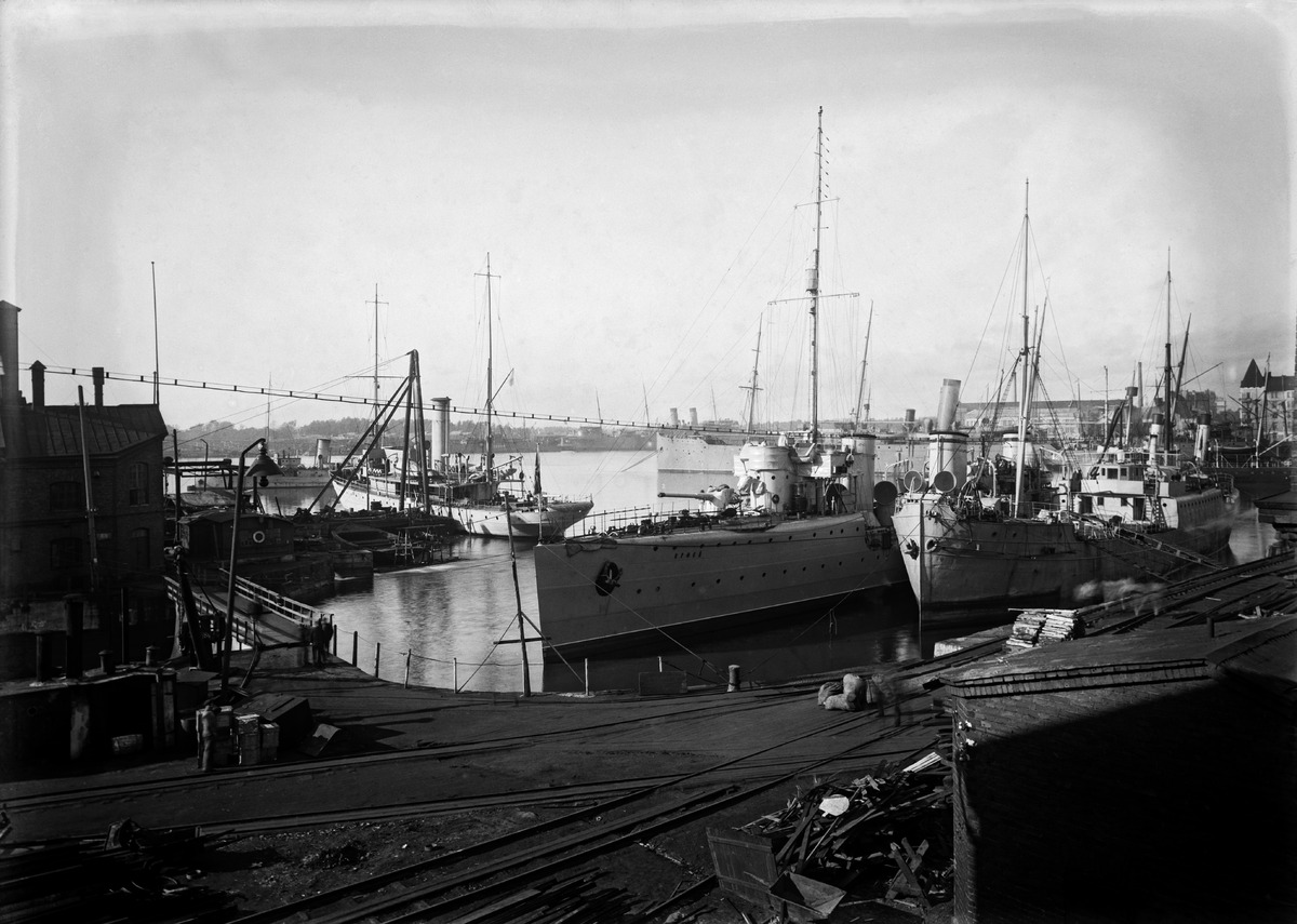 Venäläinen sotalaiva Orfei ja laivoja Hietalahden telakan edustalla, taustalla Hietalahdenrantaa