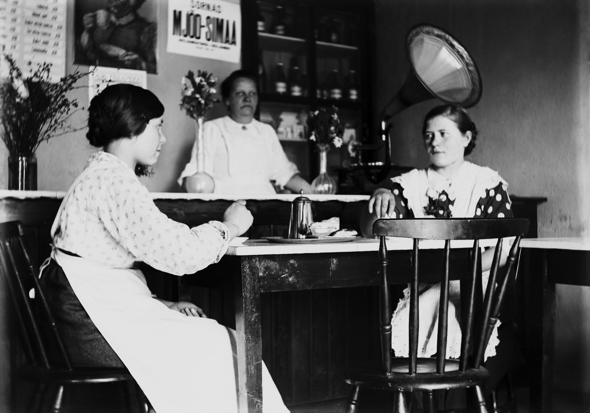 Kahvilatyöntekijöitä poseeraamassa kahvilassa, takana gramofoni