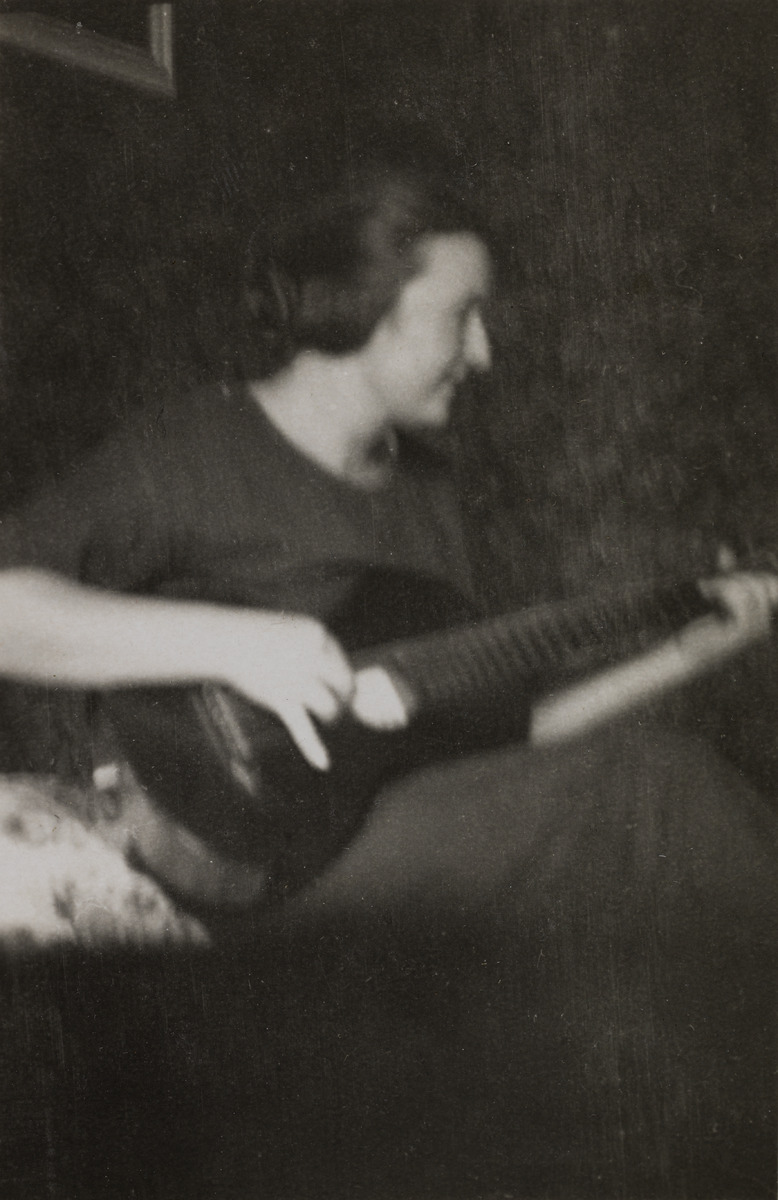 Keraamikko Friedl Holzer-Kjellberg (1905-1993) soittamassa kitaraa huoneessaan Villa Miramarissa