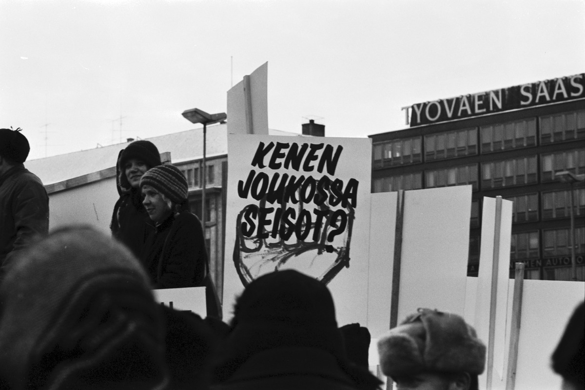 Kallio Siltasaari Hakaniementori Hakaniementorilla Metallityöväen liiton lakon aikana mielenosoittajia ja juliste, jossa teksti "KENEN JOUKOISSA SEISOT?"
