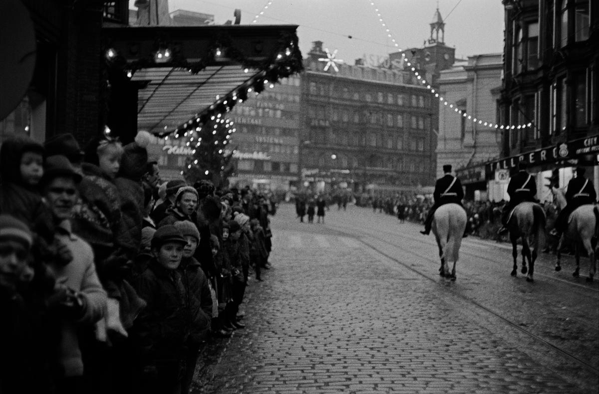 Joulukadun avajaiset Aleksanterinkadulla, kolme poliisia ratsastaa kulkueen kärjessä Stockmannin kohdalla.